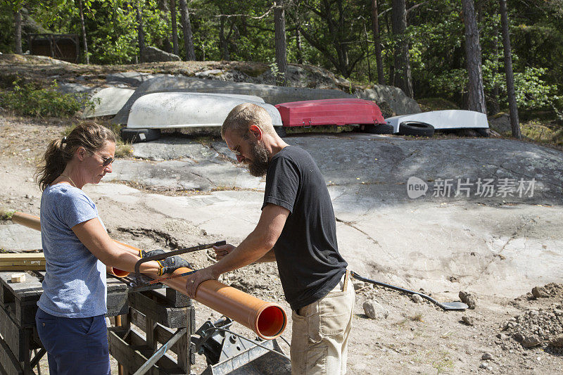 团队合作，男男女女准备排水管道。瑞典