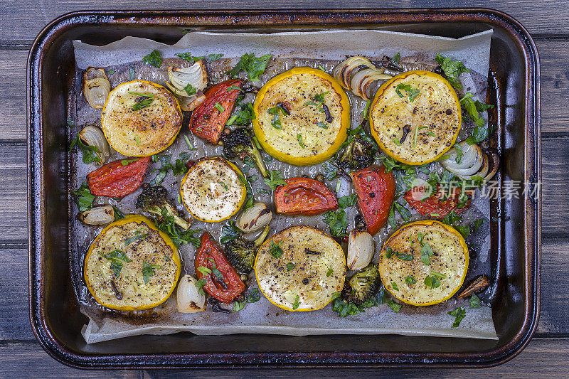 西葫芦，西红柿，花椰菜，洋葱和欧芹在烤箱里烤。俯视图