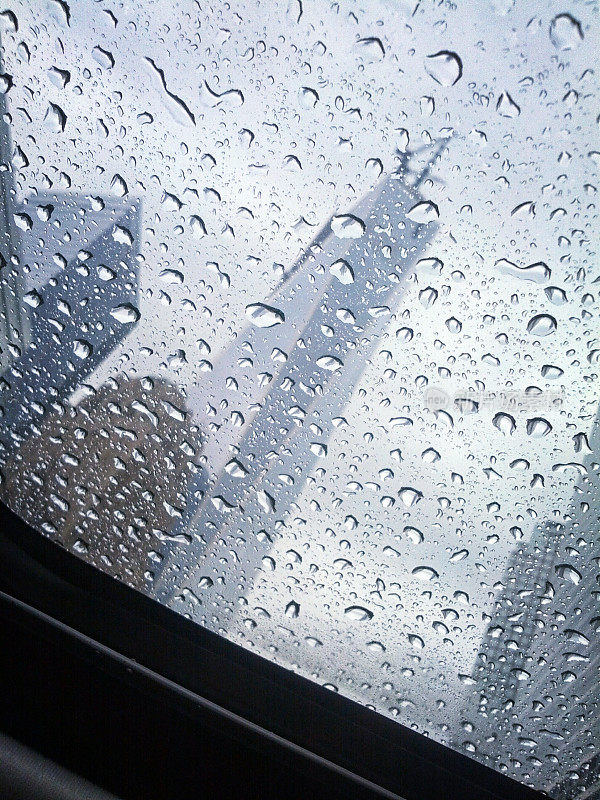 世贸中心1号大楼正在建设中，雨滴溅在汽车天窗上