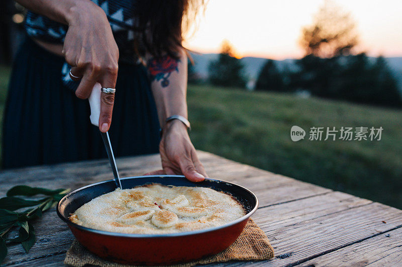 在一张质朴的木桌上切一块美国樱桃派