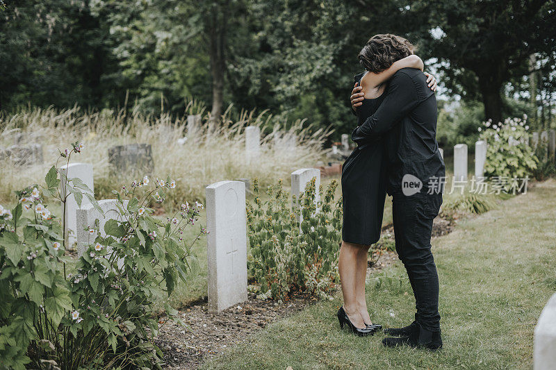 丈夫在墓地安慰他的妻子