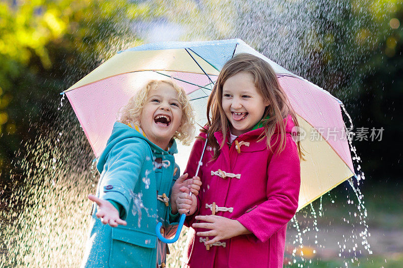 孩子们撑着伞在秋雨中嬉戏。