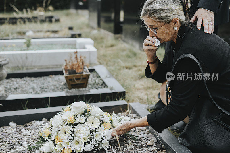 老妇人在坟墓上放花
