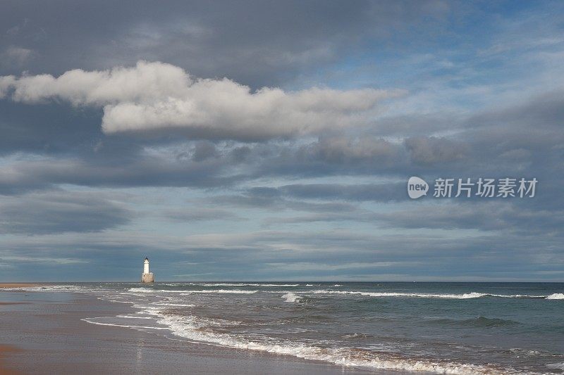 沙丘、海滩和大海上的云，远处有灯塔