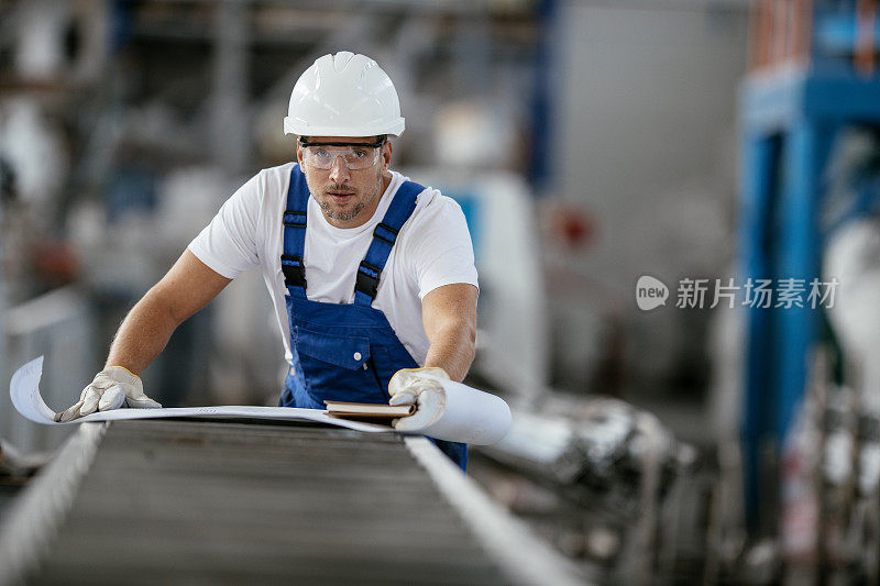 带蓝图的工厂工人