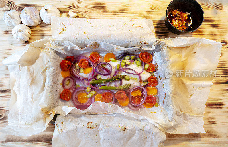 自制羊皮纸烤鱼片，配洋葱，番茄和芦笋