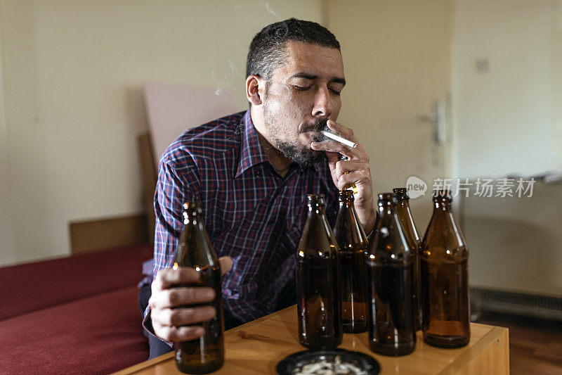 年轻悲伤的醉酒男子喝啤酒和酒精感到浪费，孤独和绝望的痛苦和情绪压力。人与酗酒、上瘾和男人抑郁的概念。