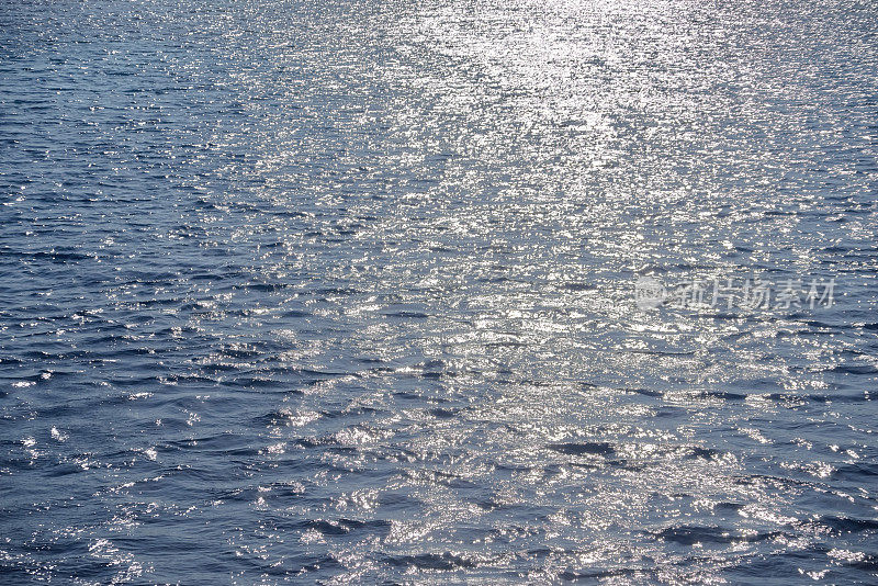 蓝色的海水和白色的阳光反射，波纹的水面背景