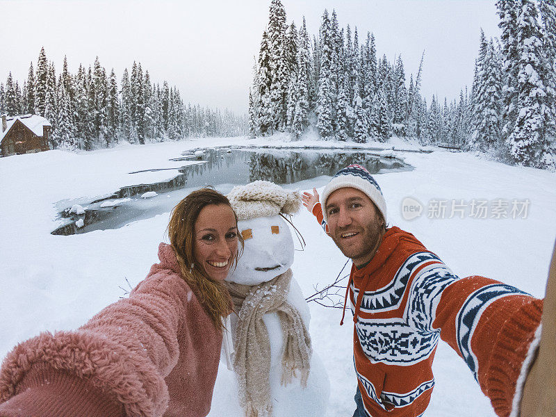 一对夫妇在寒假和雪人自拍