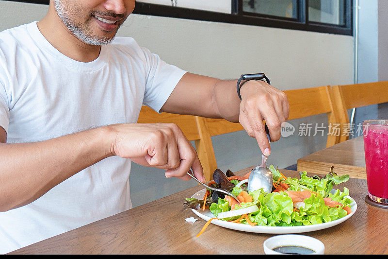 年轻快乐的男人享受着健康的饮食