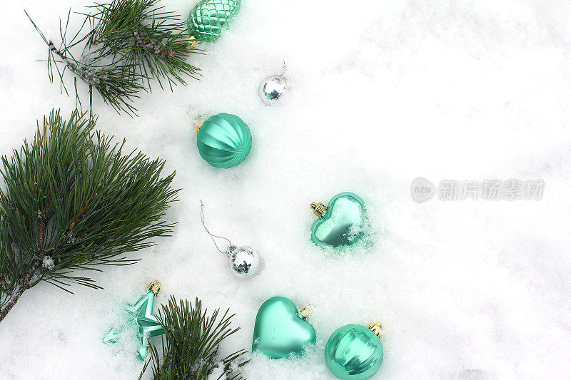 银色，绿松石和金色的圣诞装饰。在雪地上。俯视图，平放