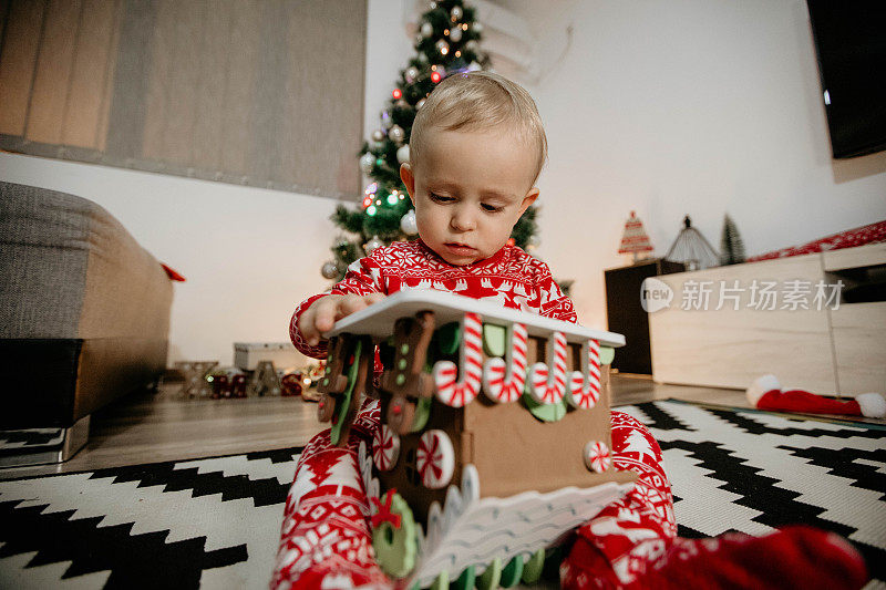 可爱的小孩在装饰好的房间里玩他的圣诞礼物