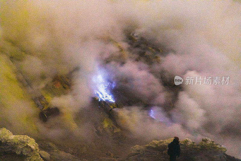 印度尼西亚东爪哇，伊真火山的壮观日出，蓝色的火焰和明亮的黄色硫磺蒸汽在绿松石湖之上