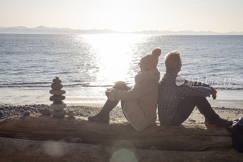 日出时分，成熟的夫妇在海滩上放松
