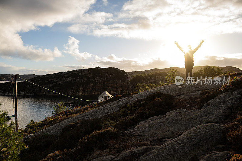 女人的户外冒险:在日落的挪威徒步旅行