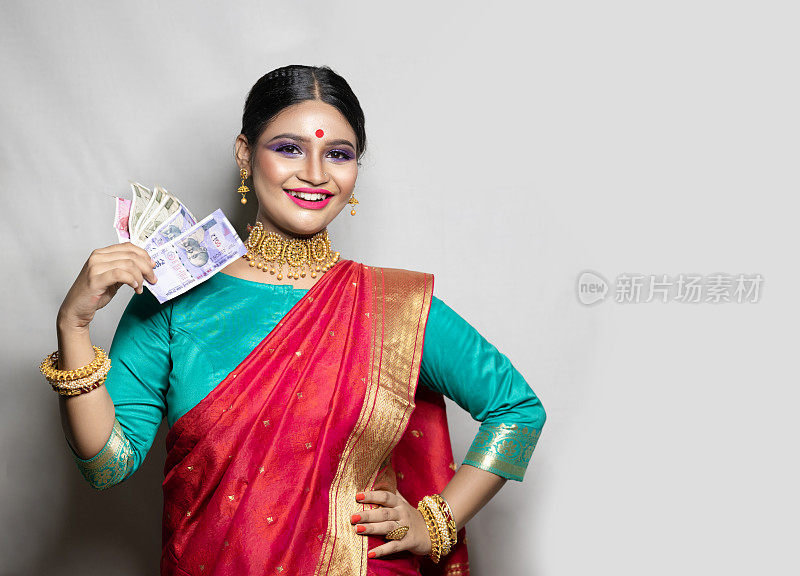 快乐的女人拿着印度卢比钞票