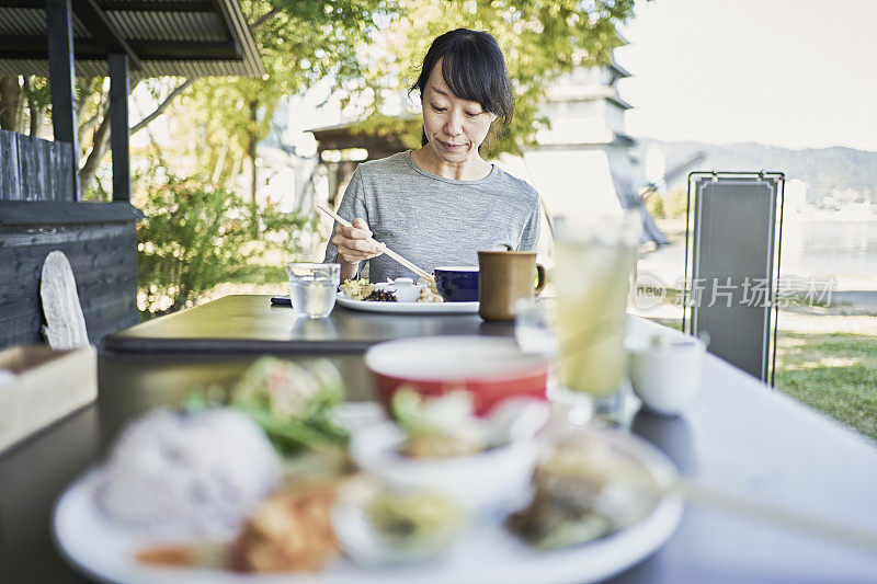 一位日本妇女在一家素食餐厅的露台上享用素食餐。