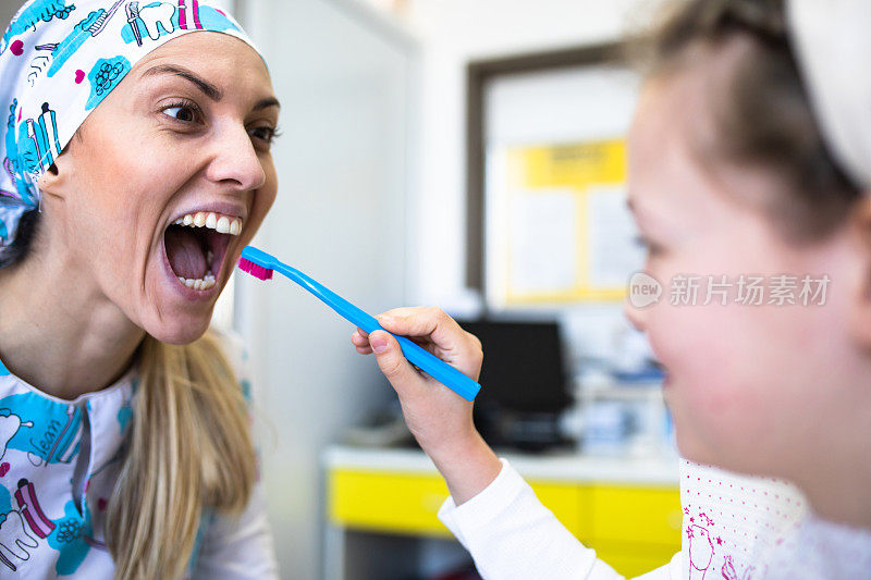 一位儿科牙医正在给她的小病人刷牙