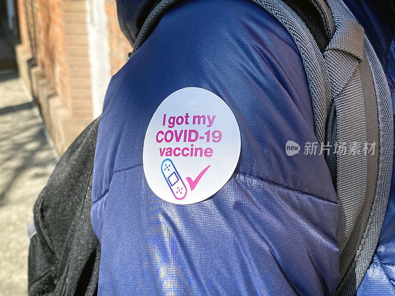 贴有“我拿到了COVID-19疫苗”贴纸的人