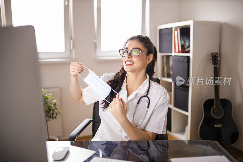 在冠状病毒大流行期间，微笑的女医生在数字平板电脑上与患者视频通话