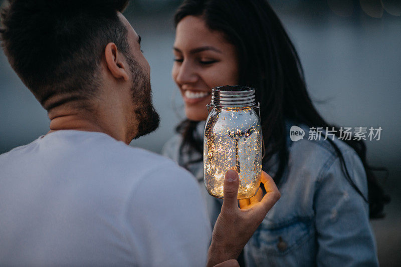 幸福的年轻夫妇花时间一起在河边的户外