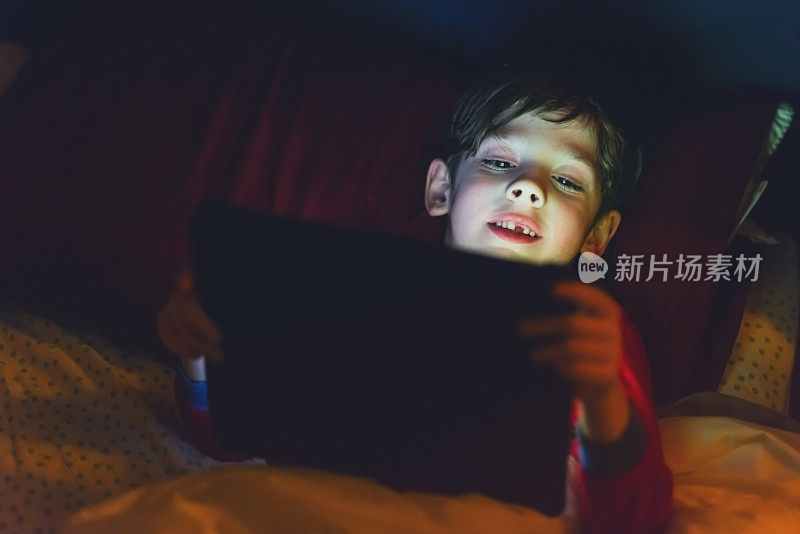 男孩在睡前使用平板电脑