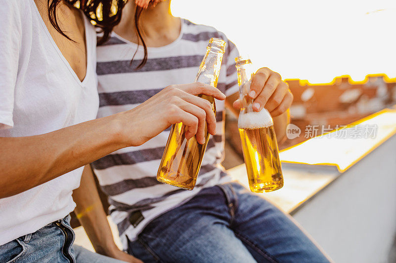 女性和男性手握啤酒瓶的特写照片