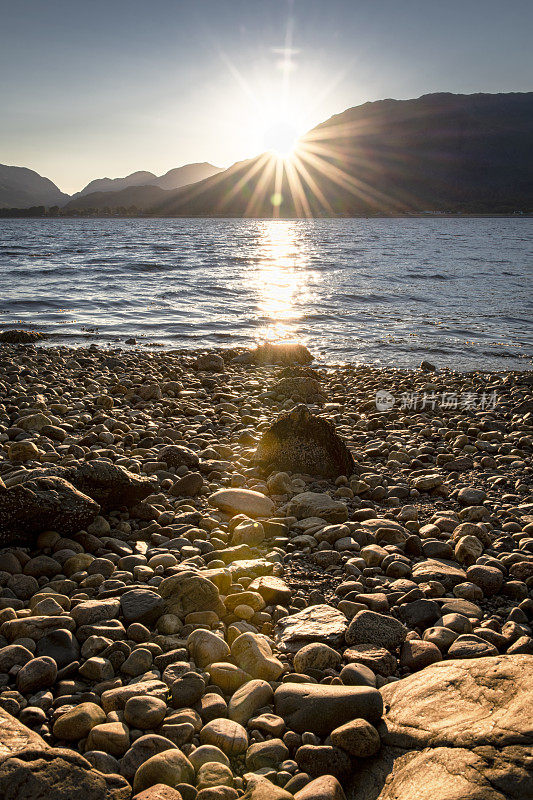 太阳从阿德古尔半岛的群山中迸发出来，在苏格兰的林荷湖落下。