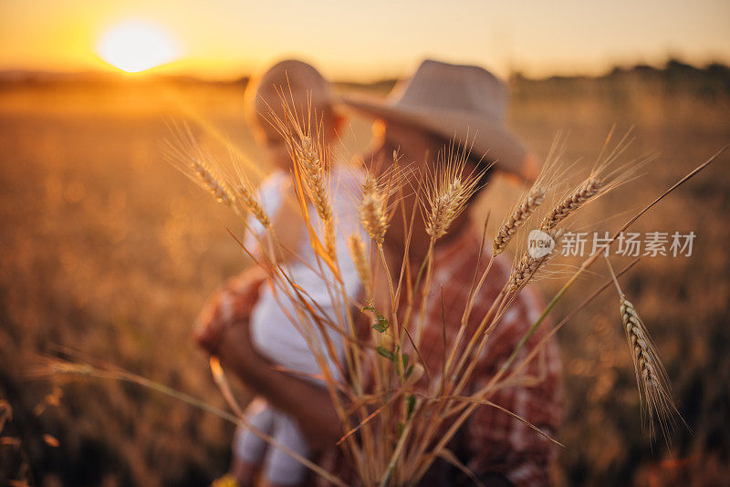 一位上了年纪的农民和他的孙子在麦田里