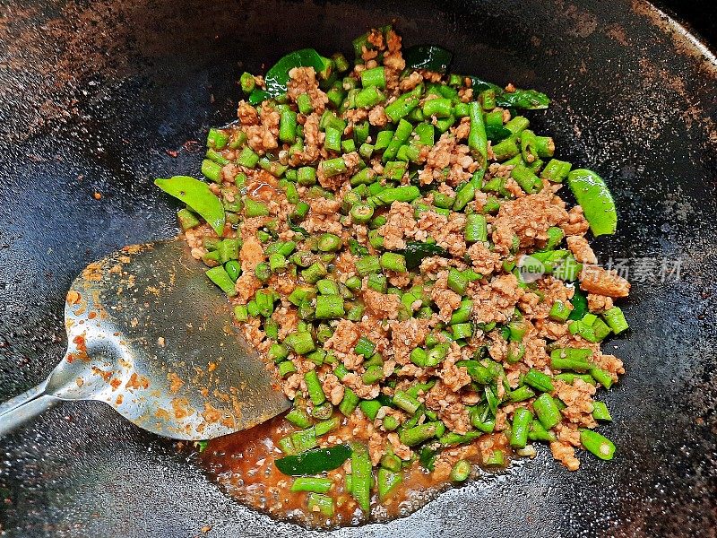 用炒锅炒青豆肉。