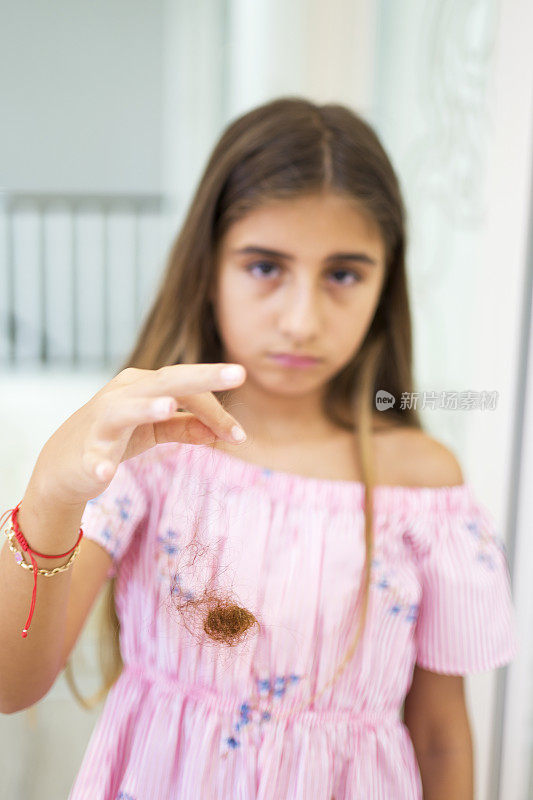 漂亮女孩在梳子上掉了头发