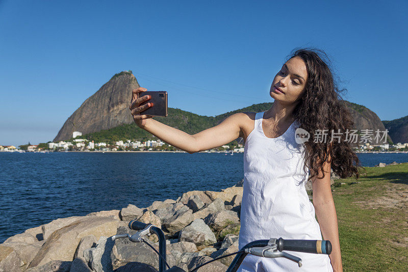 一名年轻女子在弗拉门戈公园自拍，背景是甜面包山。