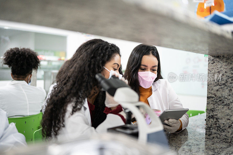 学生们在实验室里学习，戴着口罩