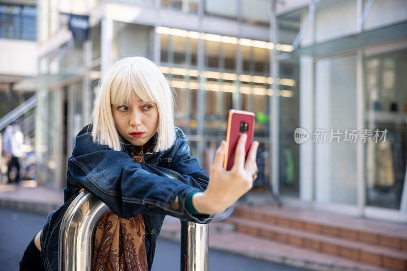 年轻女子戴着铂金假发在街上自拍