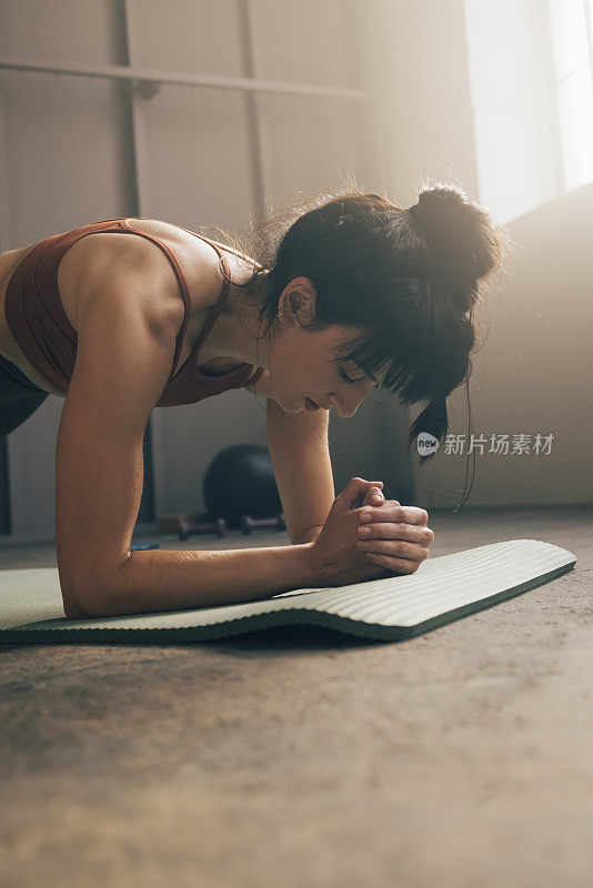 美丽的女人在健身房平板姿势的特写照片