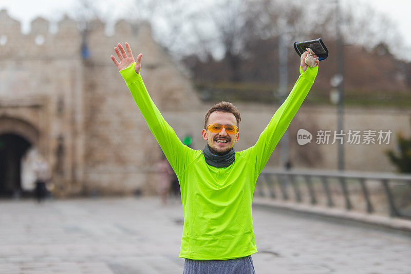 一个年轻男性跑步者穿着充满活力的跑步服庆祝他的新记录的肖像