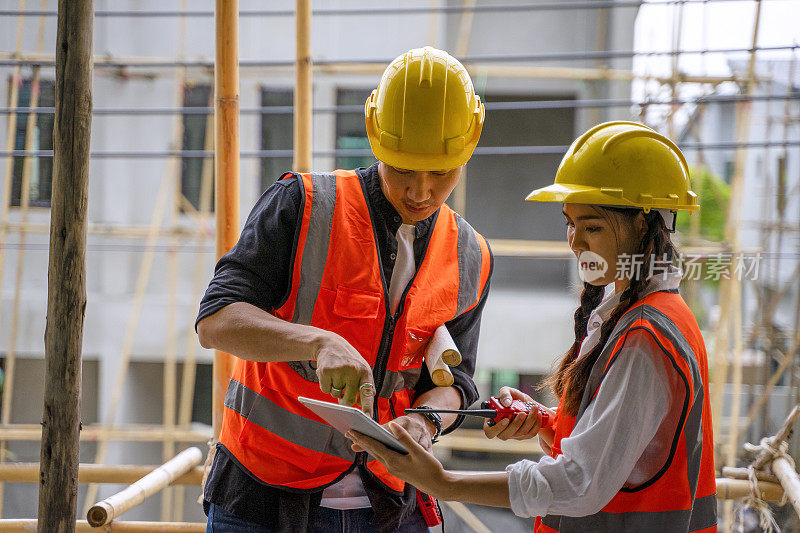 蓝领工人在建筑工地与同事一起工作。