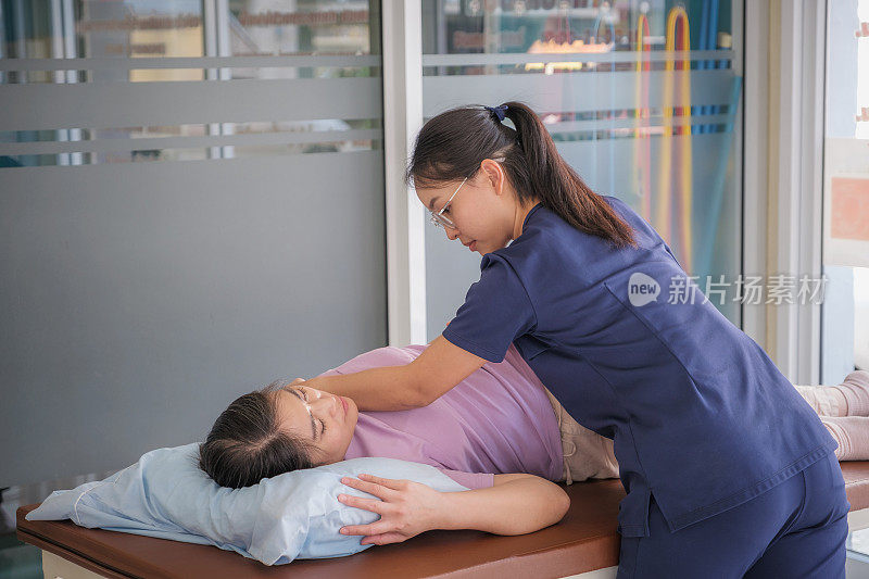 与女医生或物理治疗师进行脊椎按摩背部，手臂和肩膀调整的亚洲女性患者的医疗访问