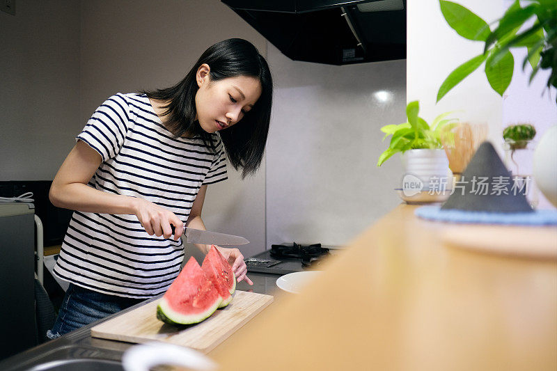 在厨房切西瓜的女人