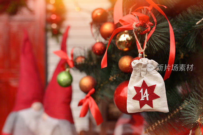圣诞节的背景。以环保袋的形式出现的日历挂在圣诞门廊的背景上。圣诞礼物和任务