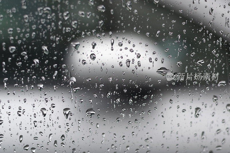 雨点打在车窗上，勾勒出汽车的轮廓