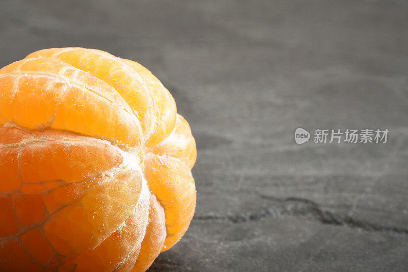 橘，剥了皮的橘橘在灰色花岗岩的背景上