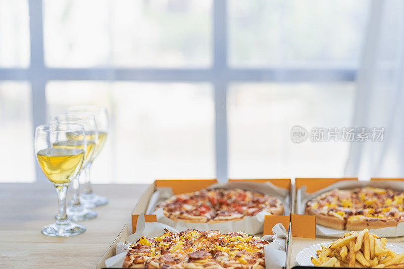 一群吃意大利披萨的员工在午餐或晚餐店手工挑选披萨。美味的海鲜肉汁酱。传统的意大利快餐在木桌上喝葡萄酒。