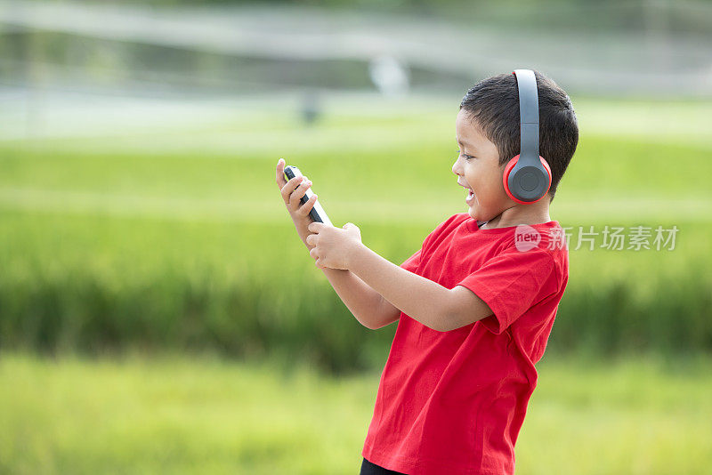 蹒跚学步的男孩用耳机听音乐