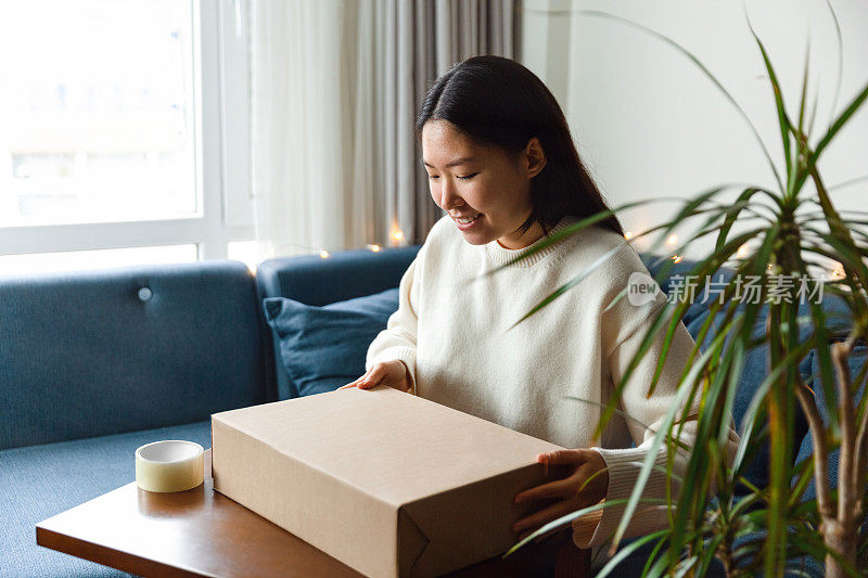 年轻女子用礼物打开包裹