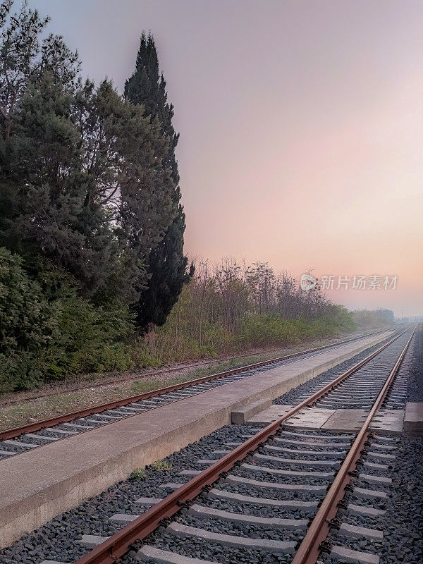 美丽的风景与铁路或铁路透视在雾日落