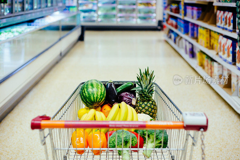 超市里装满健康水果和蔬菜的购物车