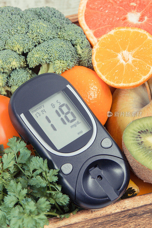 葡萄糖计，用于检查血糖水平和水果与蔬菜在木箱。糖尿病，饮食和瘦身的概念