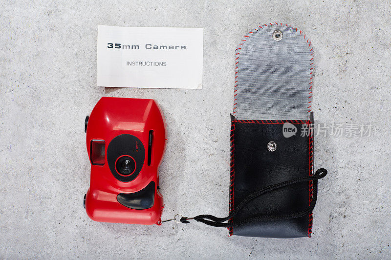 红色35mm点和拍摄胶片相机，附有说明书和皮革手提箱