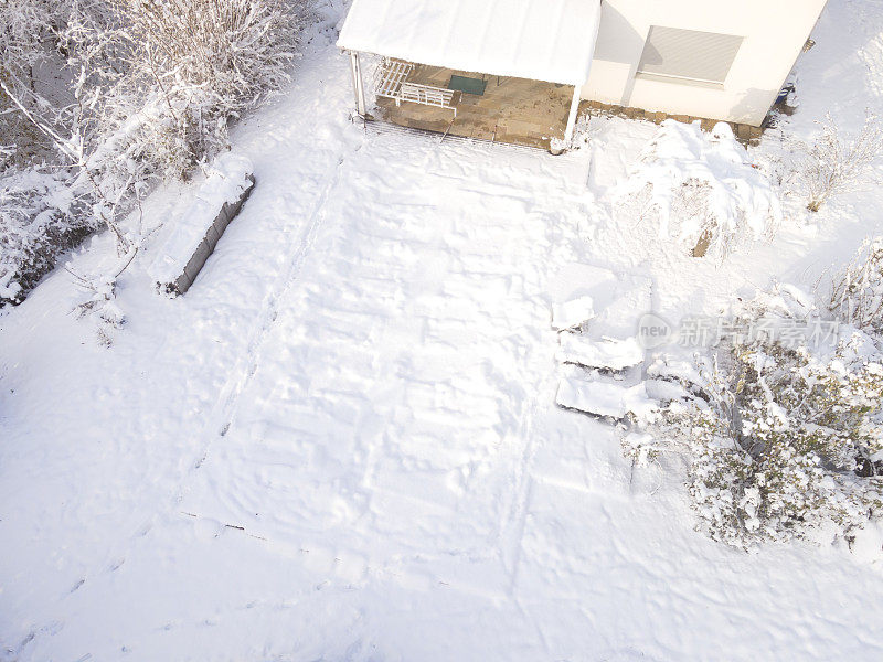 空中无人驾驶飞机飞过覆盖着防水油布的游泳池，冬天下雪，很冷